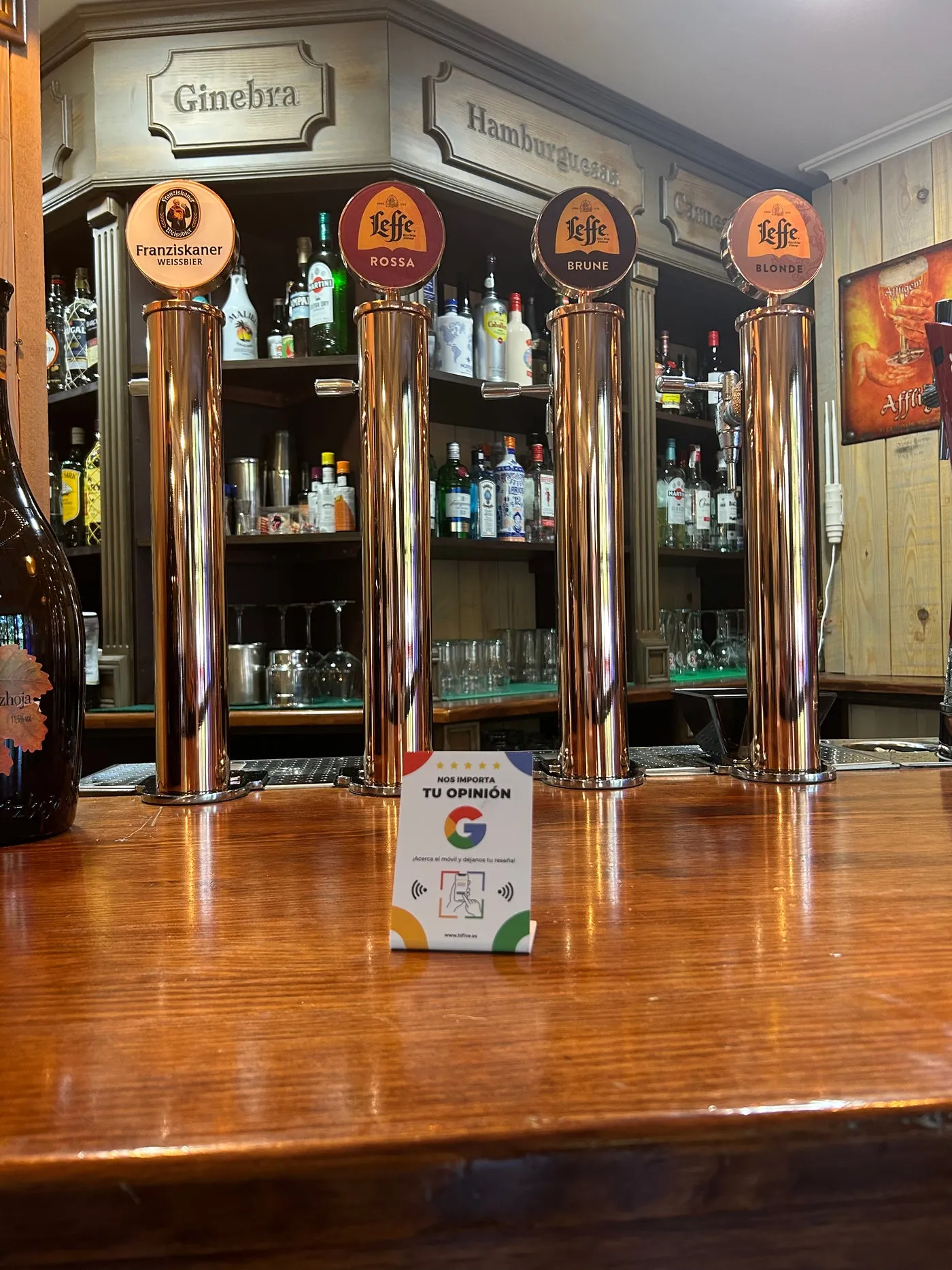 Expositor en la barra de un bar, delante de los grifos de cerveza